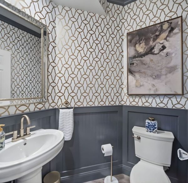 Bathroom renovation with patterned wall tile, pedestal sink, and ceramic floor tile.